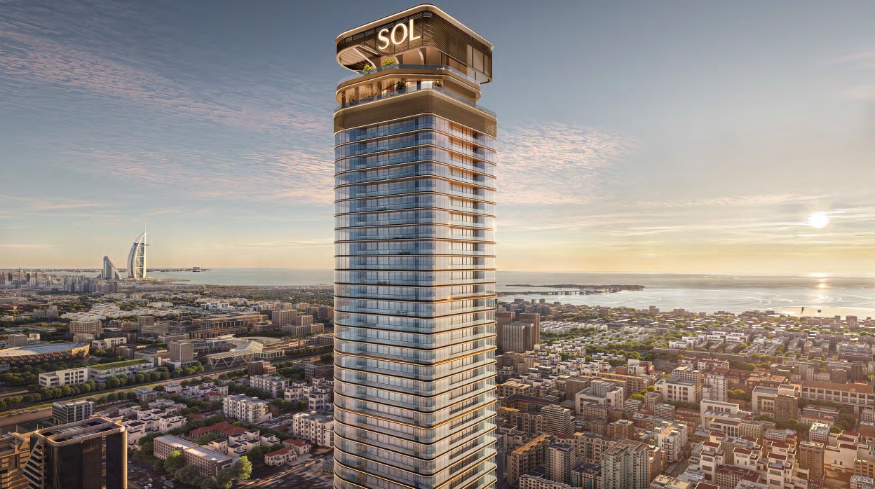 Sol Luxe tower at sunset above the city, with the sea and Burj Al Arab